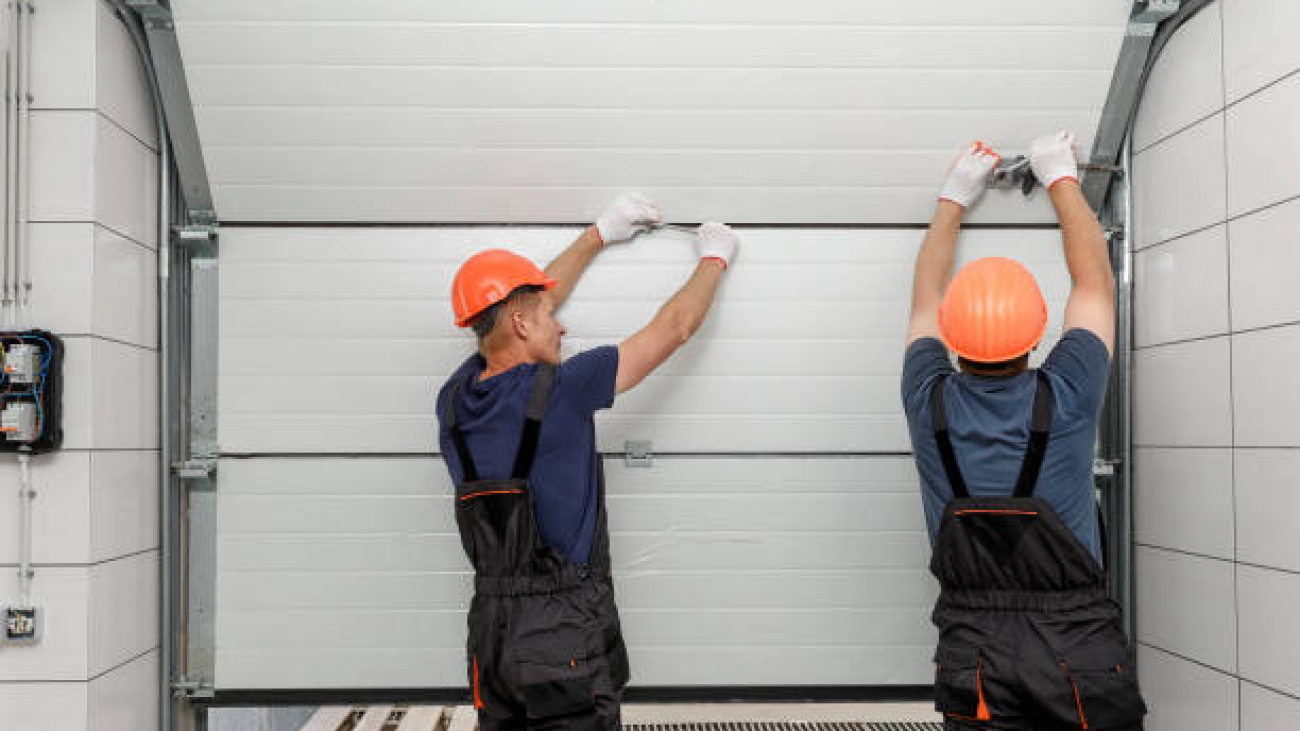 Workers are installing lifting gates of the garage.